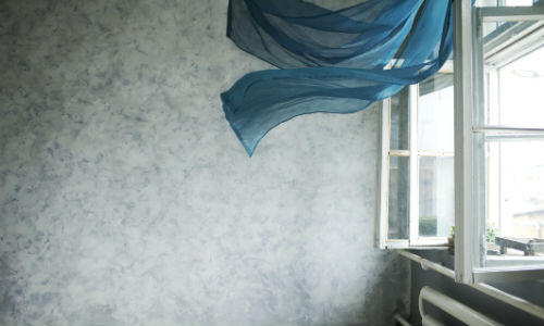 Ventilation som representeras av gardiner som blåser uppåt från ett öppet fönster